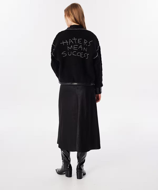 Model wearing twist tied cardigan with black skirt